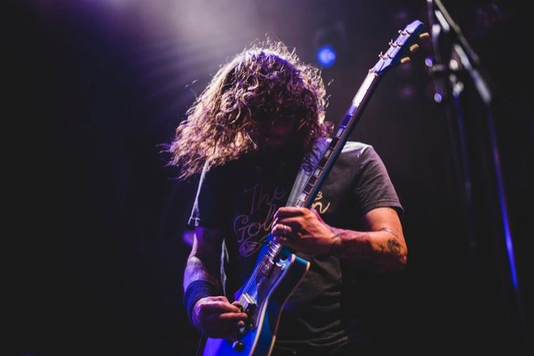 Guitarist playing live under purple stage light at a West Hollywood club