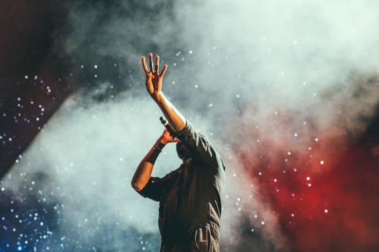 Singer raising a hand in stage smoke on the Sunset Strip